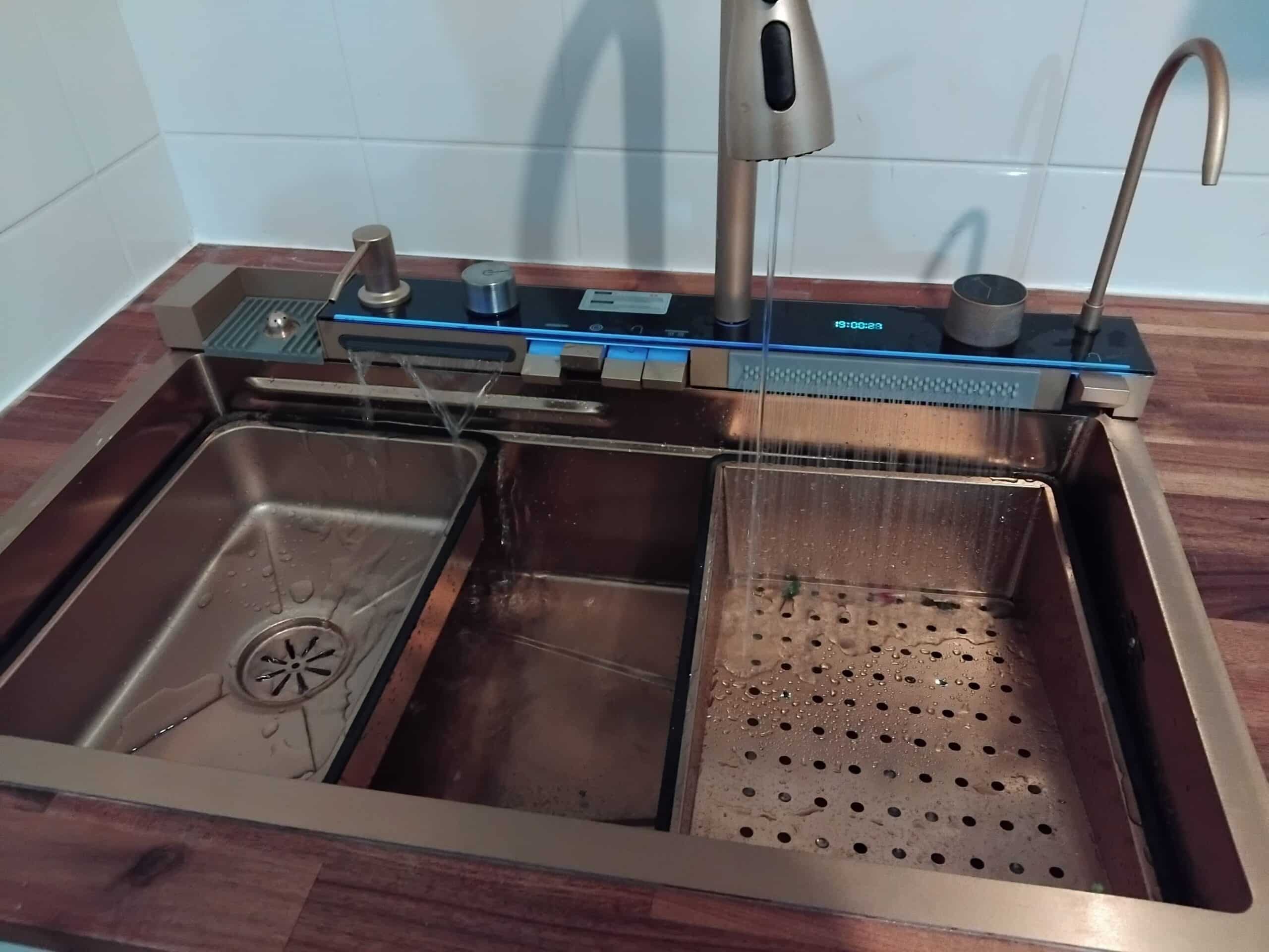 Évier de cuisine moderne en bronze avec robinet cascade, affichage numérique 19:00:22 et accessoires multifonctions.